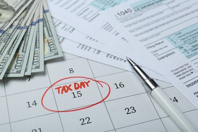 Photo of Calendar with date reminder about tax day, documents, pen and money, closeup