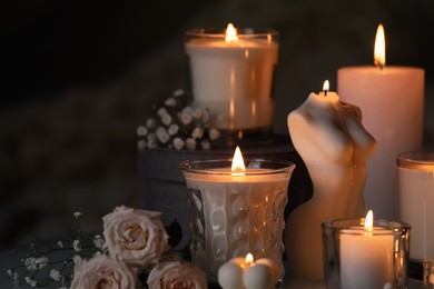 Photo of Beautiful burning candles and flowers on blurred background
