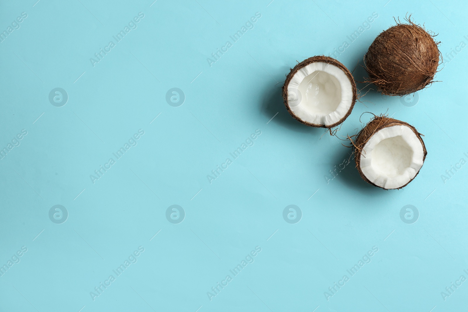 Photo of Flat lay composition with coconuts on color background. Space for text