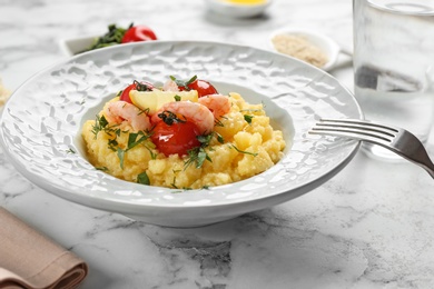 Plate with fresh tasty shrimp and grits on table