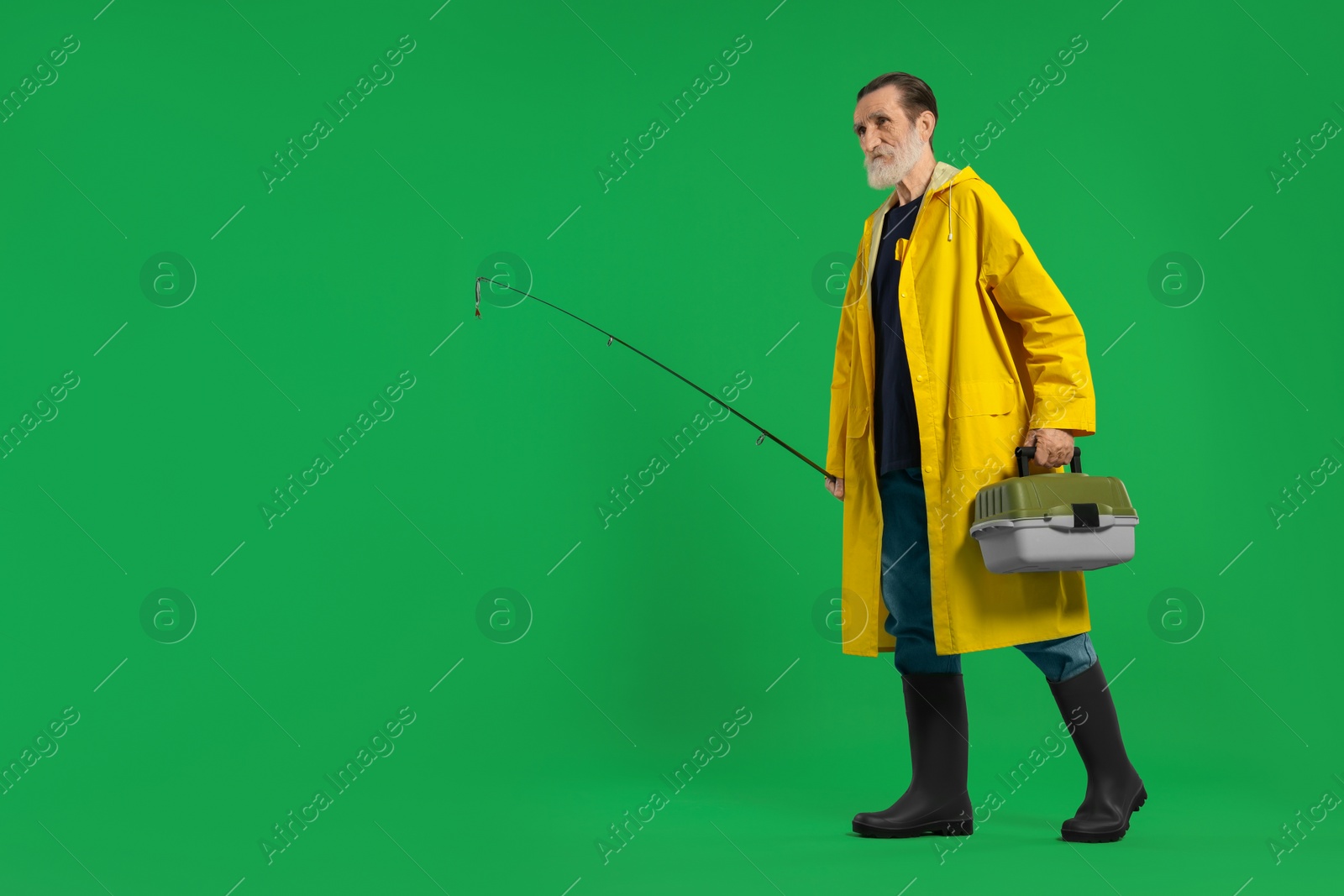 Photo of Fisherman with rod and tackle box on green background, space for text