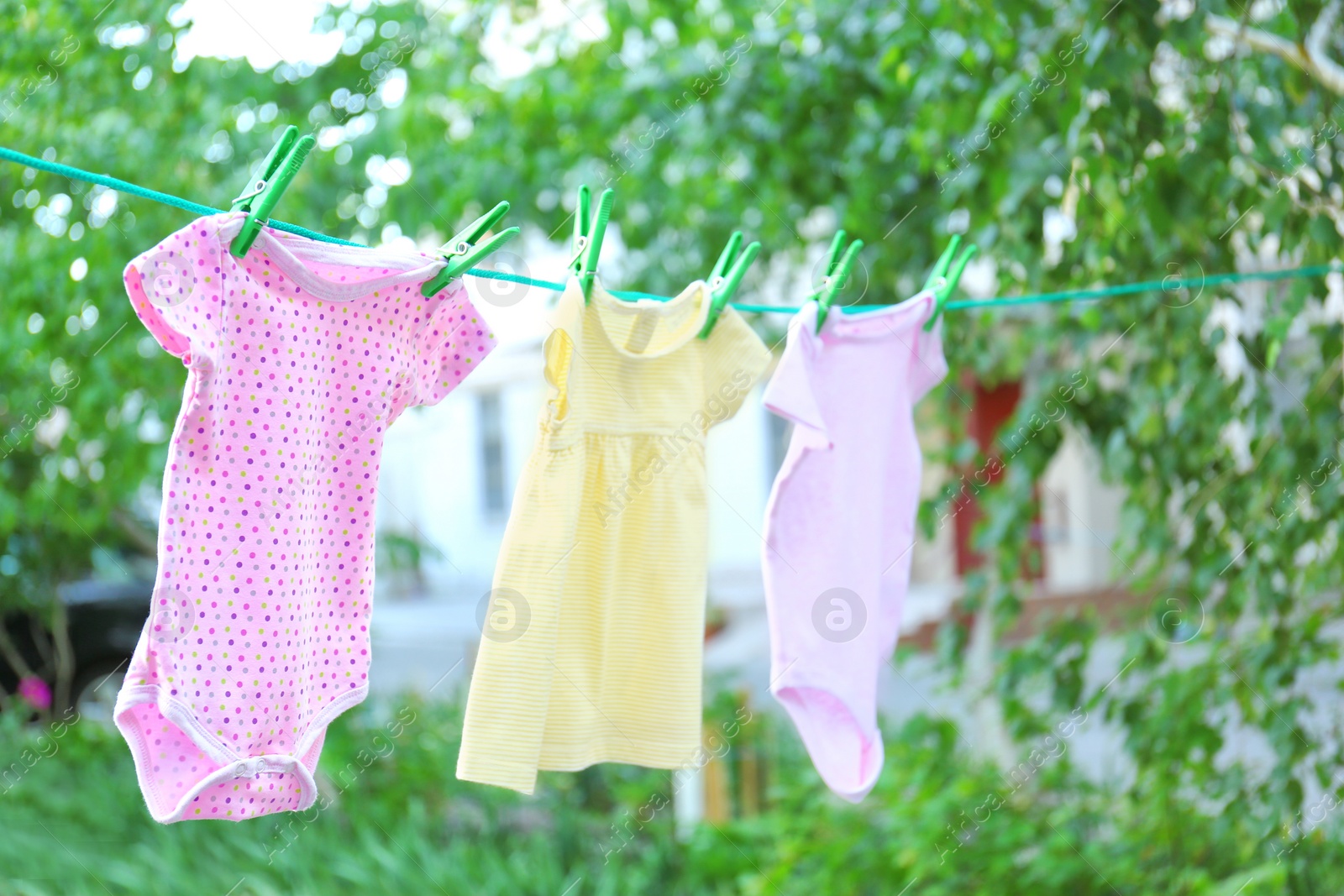 Photo of Baby clothes on laundry line outdoors on sunny day