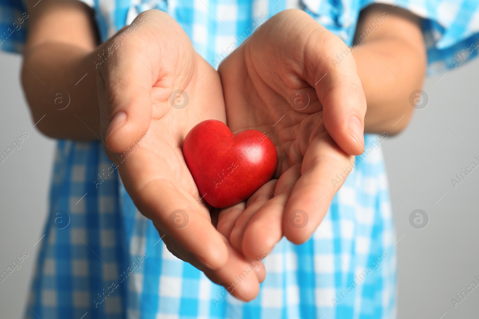 Photo of Woman holding decorative heart on color background, closeup