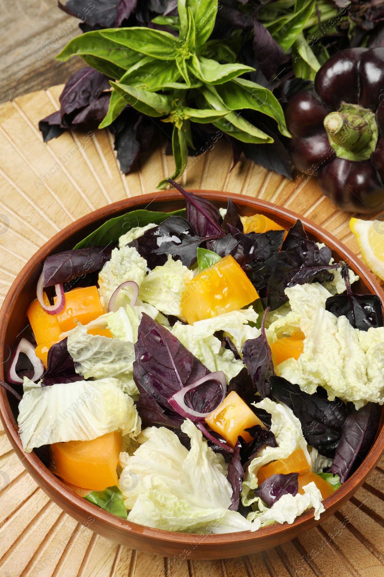 Photo of Delicious salad with Chinese cabbage, tomato and basil served on wooden table, above view