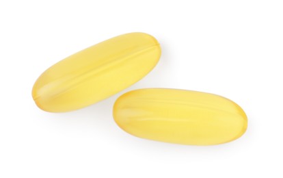 Photo of Yellow vitamin capsules isolated on white, top view