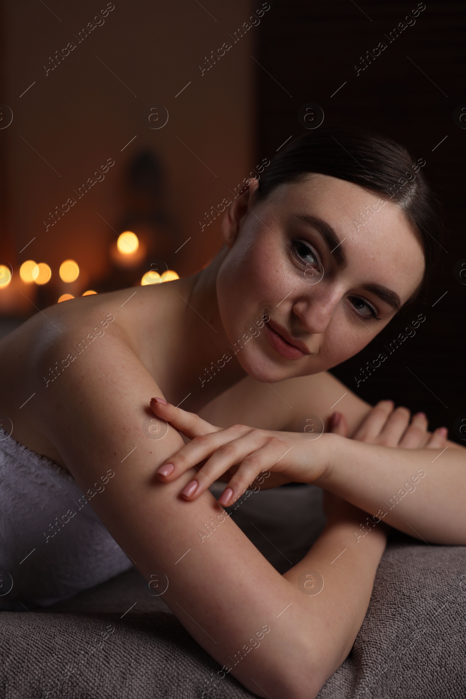 Photo of Spa therapy. Beautiful young woman lying on massage table in salon