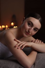 Photo of Spa therapy. Beautiful young woman lying on massage table in salon