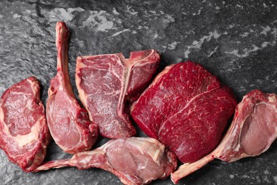 Fresh raw beef cuts on grey textured table, flat lay