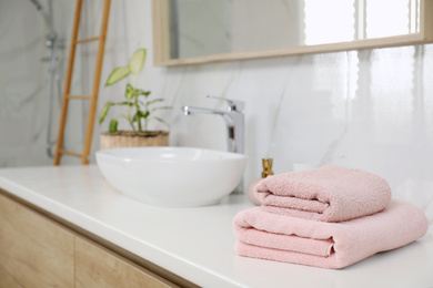 Photo of Stack of clean towels on bathroom countertop. Space for text