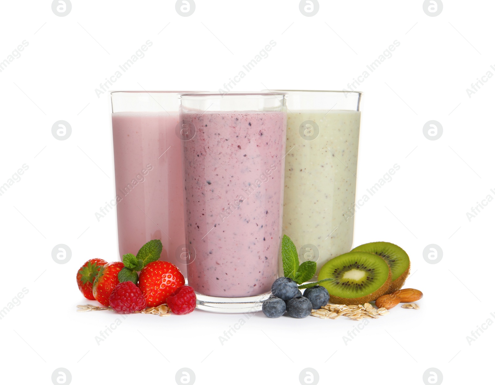 Photo of Glasses of different oatmeal smoothies and fresh ingredients on white background