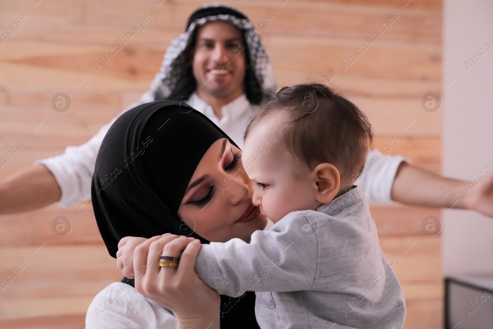 Photo of Happy Muslim family with little son at home