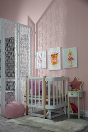 Photo of Cute pictures and crib in baby room interior