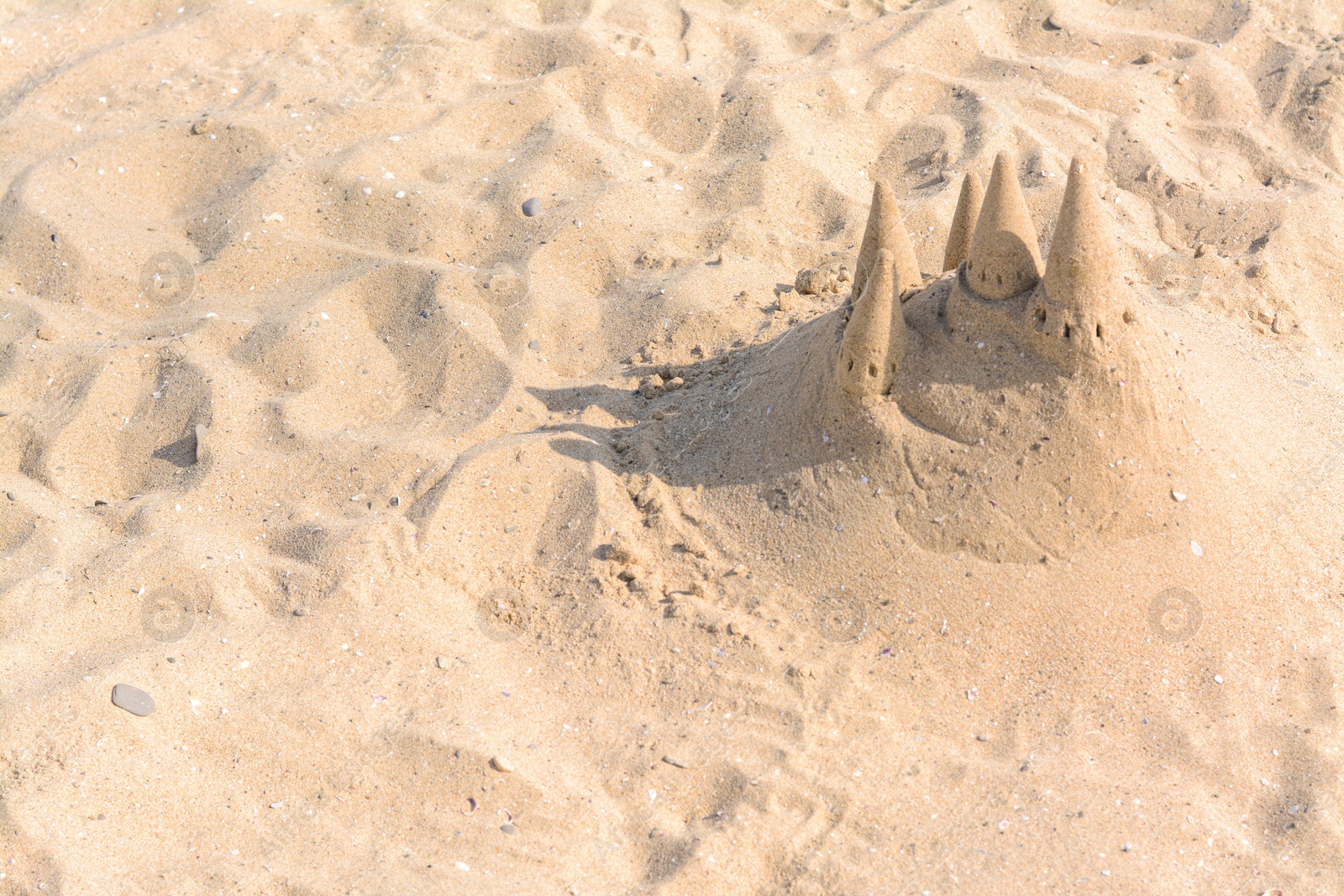 Photo of Beach with sand castle on sunny day. Space for text