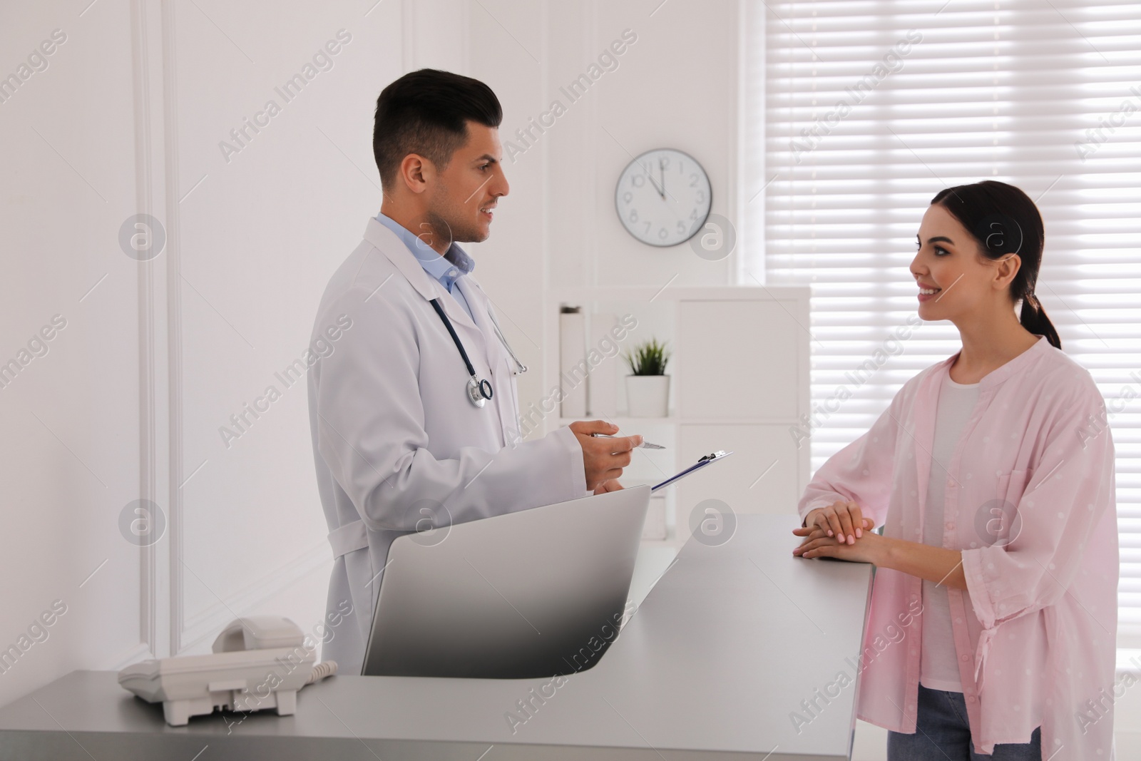 Photo of Doctor working with patient at reception in hospital