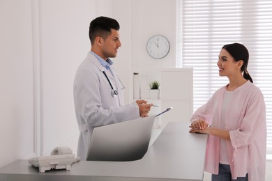 Doctor working with patient at reception in hospital