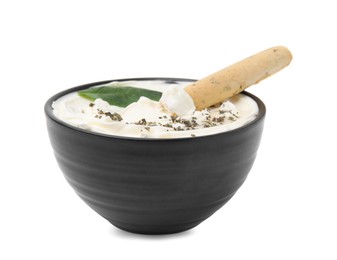 Photo of Bowl of delicious cream cheese with grissini stick, basil leaf and spices isolated on white