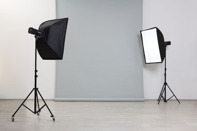 Photo of Modern light grey photo background and softboxes in studio