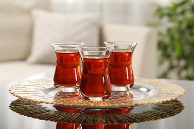 Photo of Glasses with traditional Turkish tea on table indoors