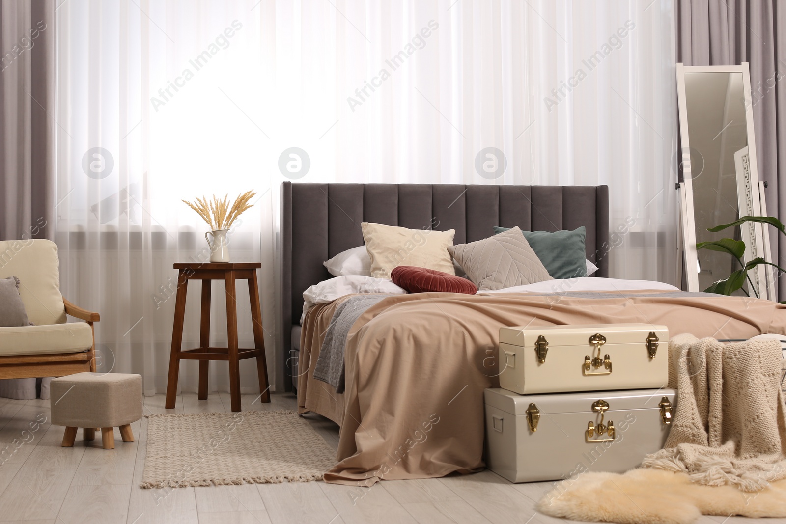 Photo of Large comfortable bed with soft pillows and blankets in room. Home textile