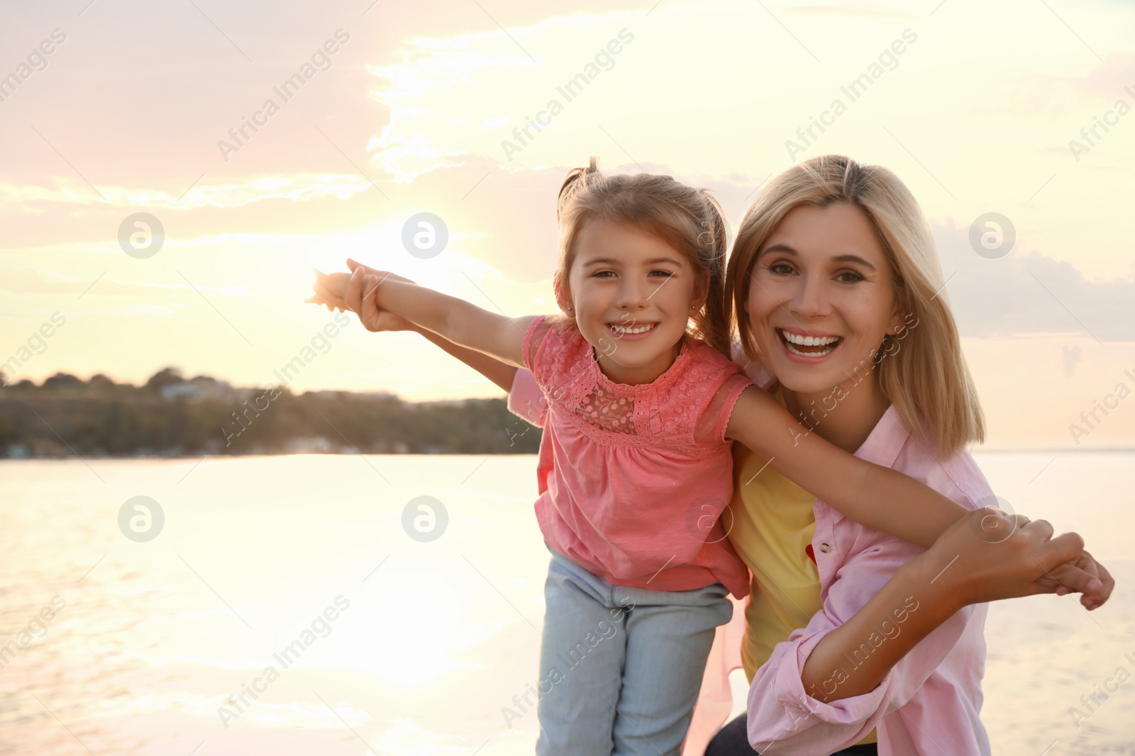 Photo of Happy mother and her child on beach. Spending time in nature