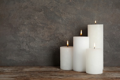 Photo of Alight wax candles on table. Space for text