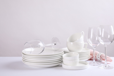 Photo of Set of clean dishes on white table