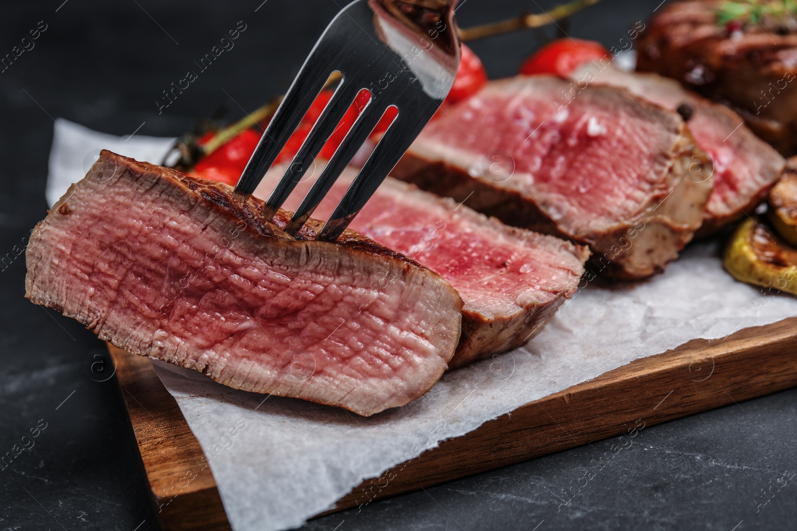 Photo of Taking slice of delicious beef steak, closeup