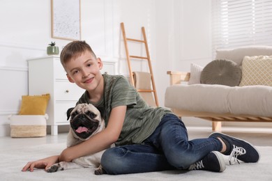 Boy with his cute pug in living room. Space for text