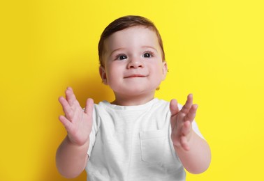 Photo of Cute happy baby boy on yellow background