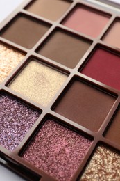 Beautiful eye shadow palette on white table, closeup