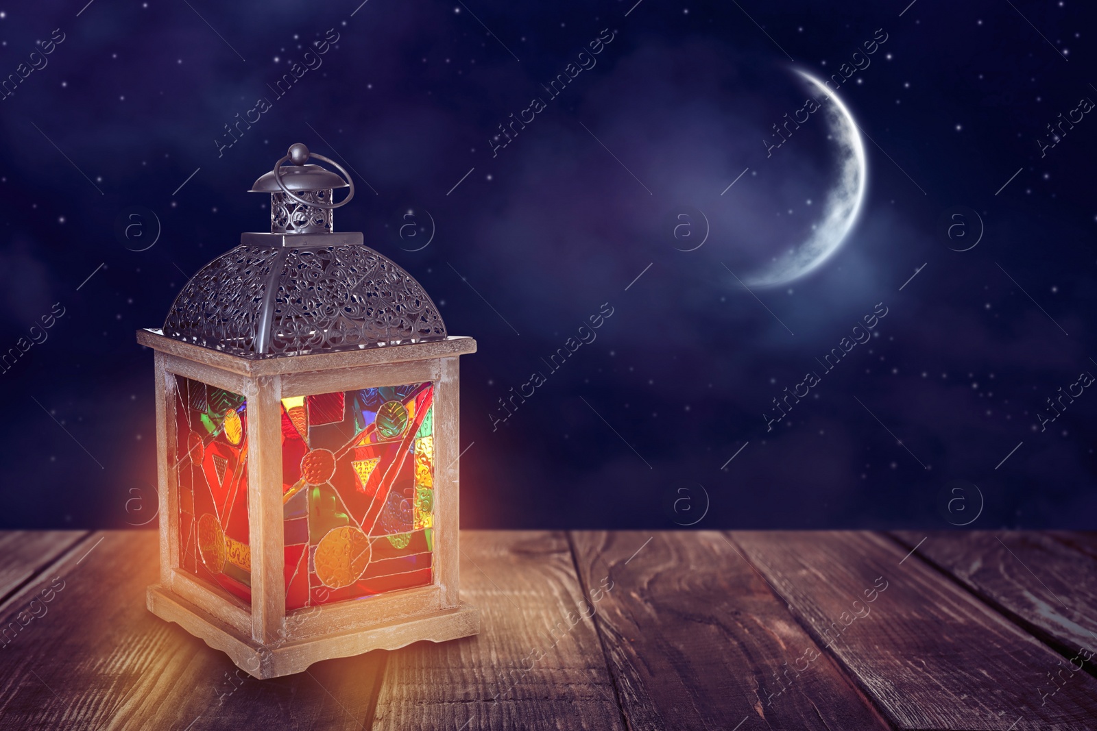 Image of Beautiful decorative Arabic lantern on wooden table at night, space for text. Fanous as Ramadan symbol