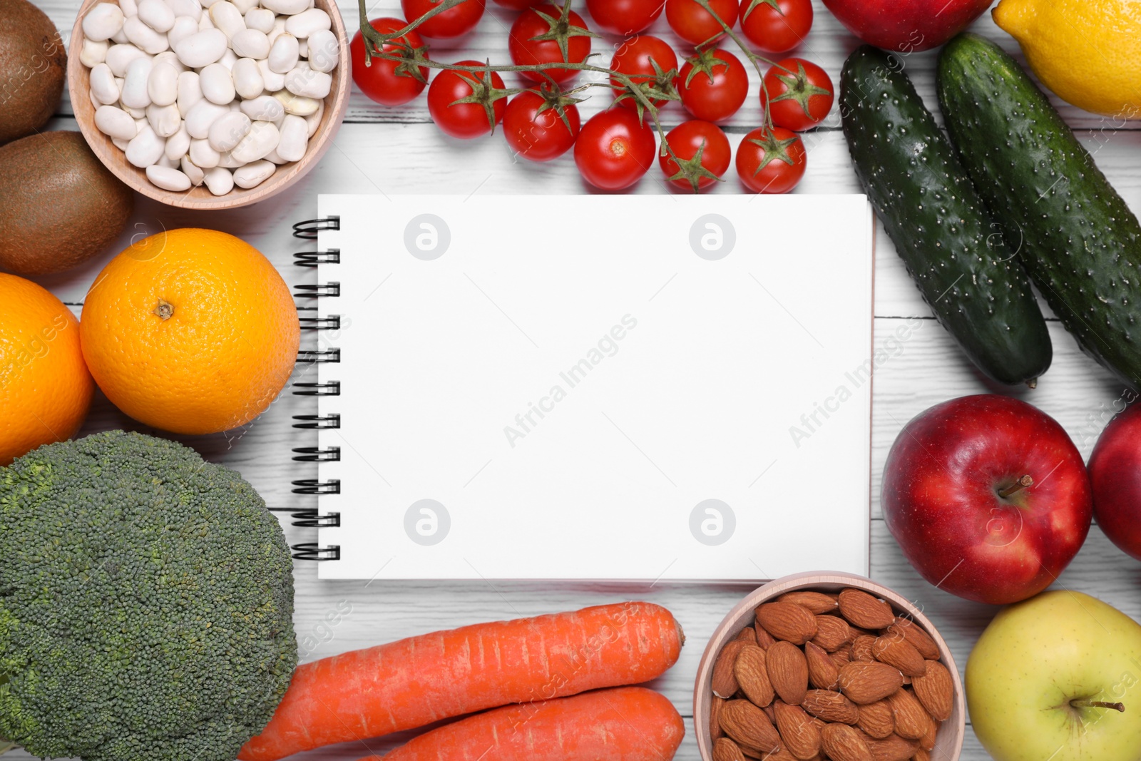 Photo of Notebook, fresh fruits and vegetables on white wooden table, flat lay. Low glycemic index diet