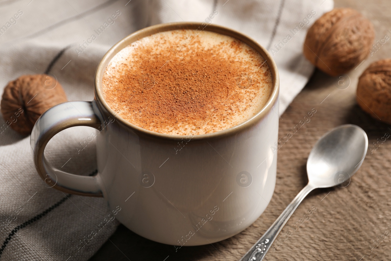 Photo of Delicious eggnog with cinnamon on wooden table, closeup