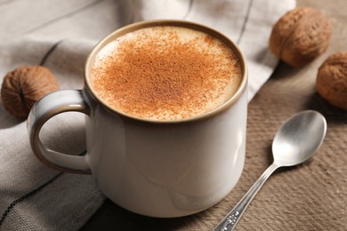 Photo of Delicious eggnog with cinnamon on wooden table, closeup