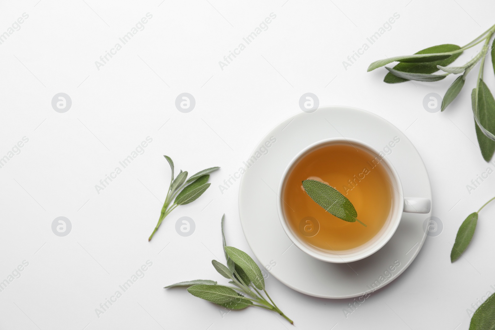 Photo of Cup of aromatic herbal tea with sage on white table, flat lay. Space for text