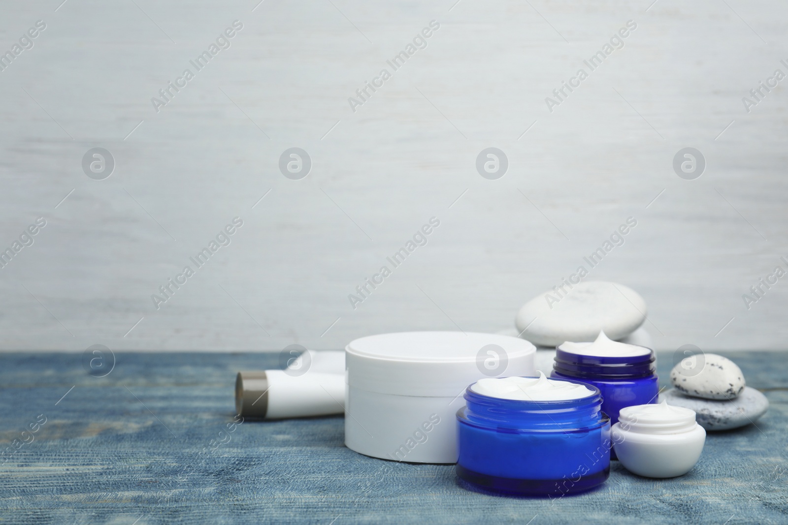 Photo of Composition with body cream in jars on wooden background