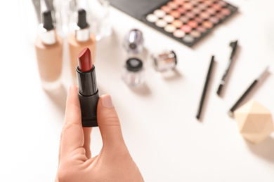 Beauty blogger with lipstick at table, closeup