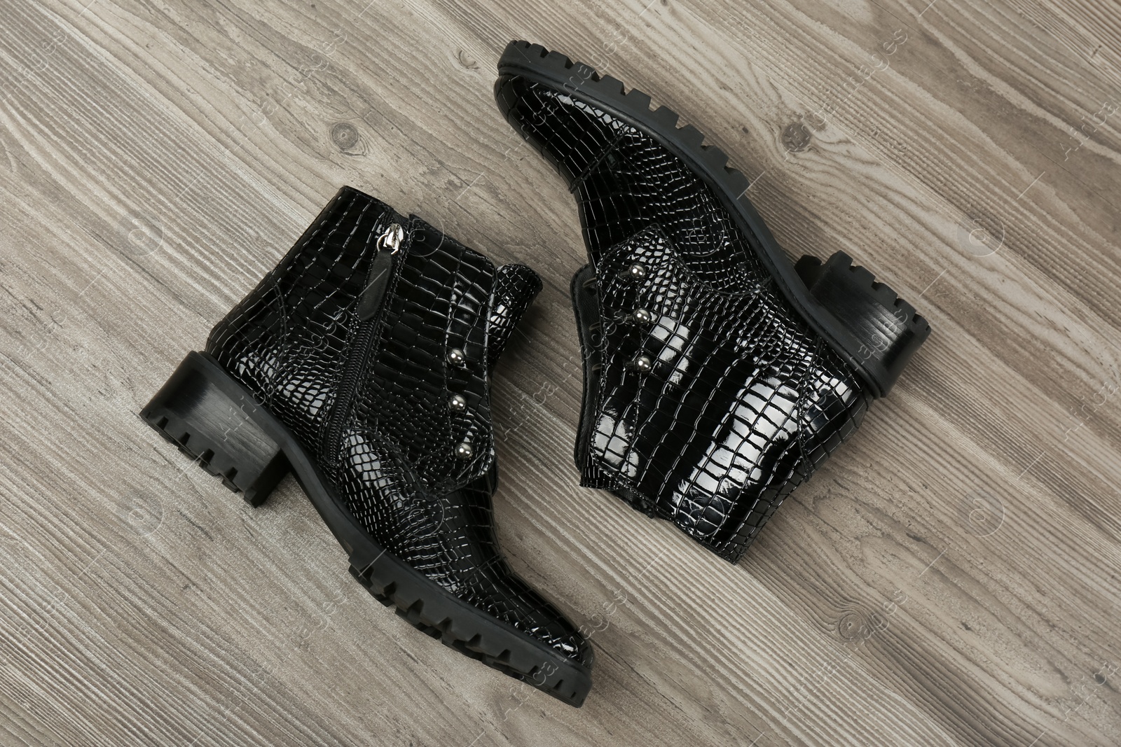 Photo of Pair of stylish ankle boots on wooden background, top view