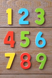 Photo of Colorful numbers on wooden table, flat lay