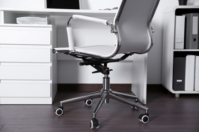 Comfortable rolling chair near table in modern office