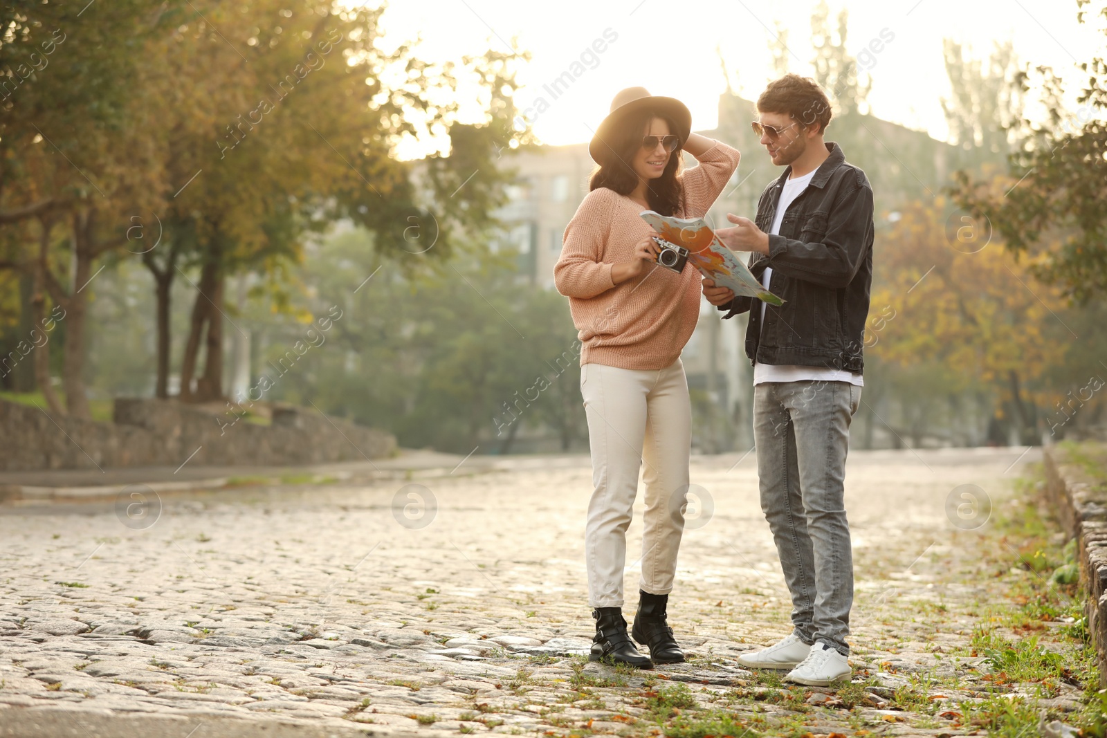 Photo of Couple of travelers with camera and map on city street