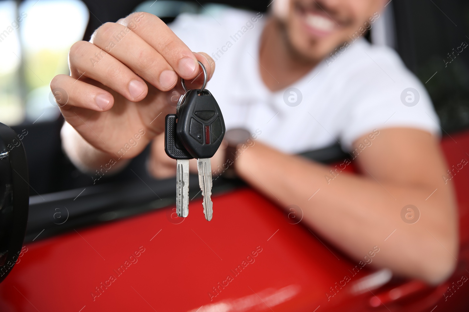 Photo of Happy man with car key sitting in driver's seat of new auto, closeup