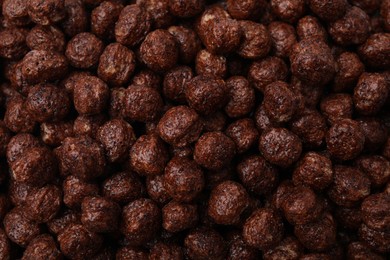 Photo of Tasty chocolate cereal balls as background, top view