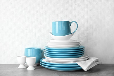 Photo of Set of dinnerware on table against light background. Interior element