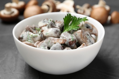 Bowl of fried mushrooms with sauce on table, closeup