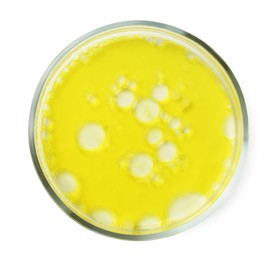 Petri dish with yellow liquid sample on white background, top view