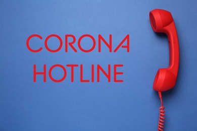 Image of Covid-19 Hotline. Red handset and text on blue background, top view