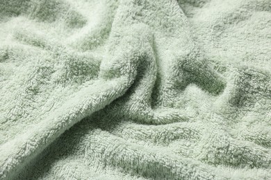 Photo of Texture of soft light green fabric as background, closeup