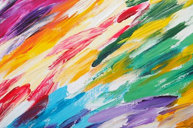 Photo of Beautiful strokes of colorful oil paints on white canvas as background, closeup