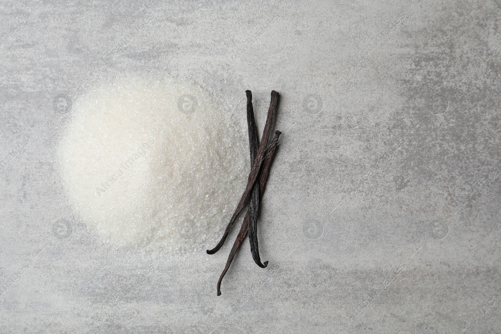 Photo of Vanilla sugar and sticks on grey background